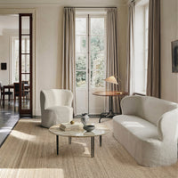 Neutral-toned fabric sofa and chair, featuring soft textures and a light, minimalist design against a warm rug.