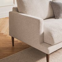 Light beige textured fabric sofa with a minimalist design and dark wood legs, pairing well with neutral tones.