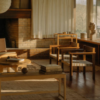 Warm wood tones, soft beige curtains, and a cozy earthy palette create a harmonious modern living space.