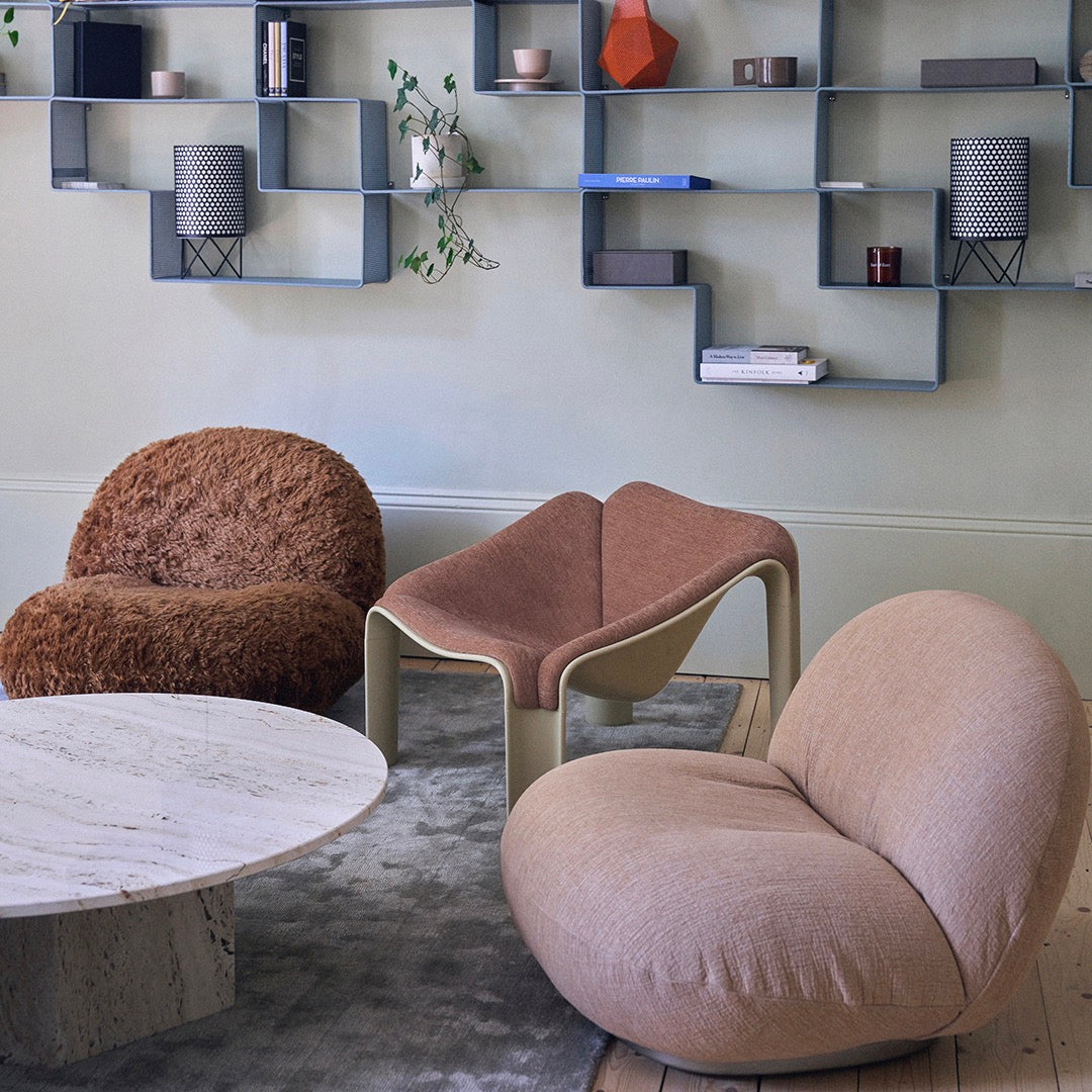 Textured brown and soft beige chairs with a pink accent table on a light gray rug in a stylish living room setting.