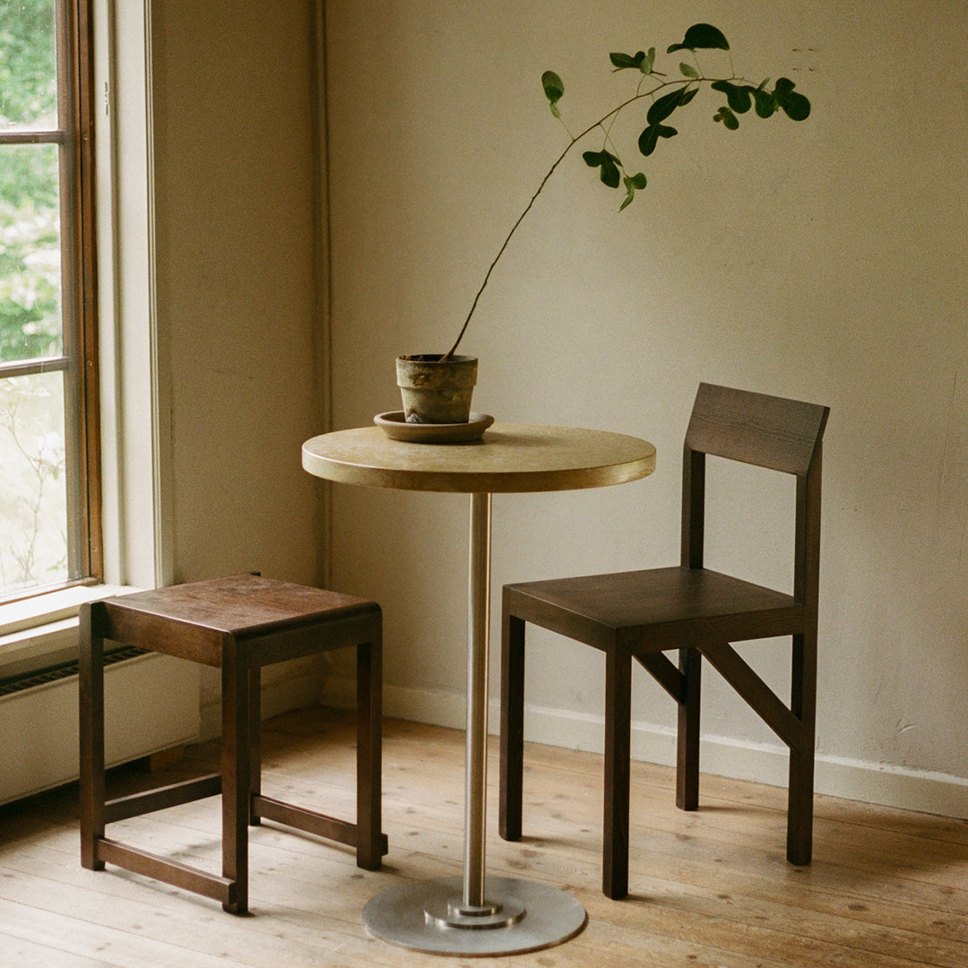 "Minimalist wooden table and chairs in natural tones, showcasing a light wood finish and dark stained accents."