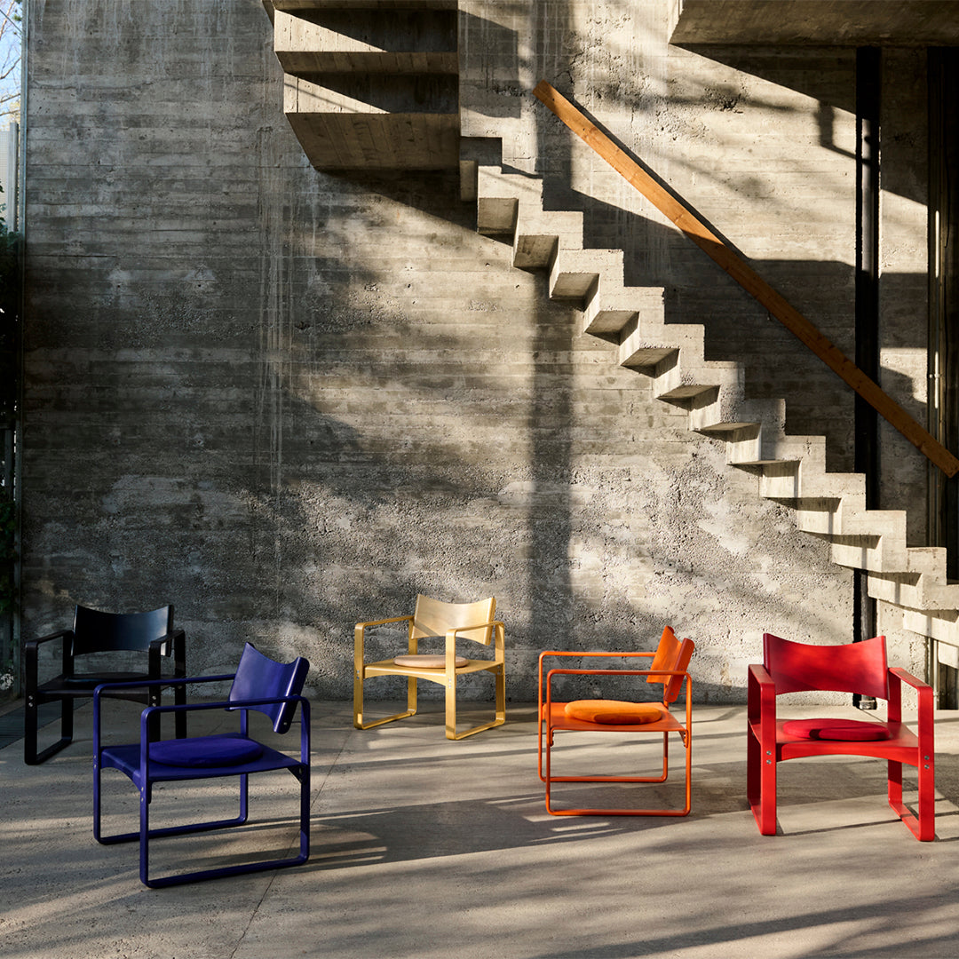 Vibrant chairs in purple, yellow, orange, red, and black showcased against a textured concrete backdrop.