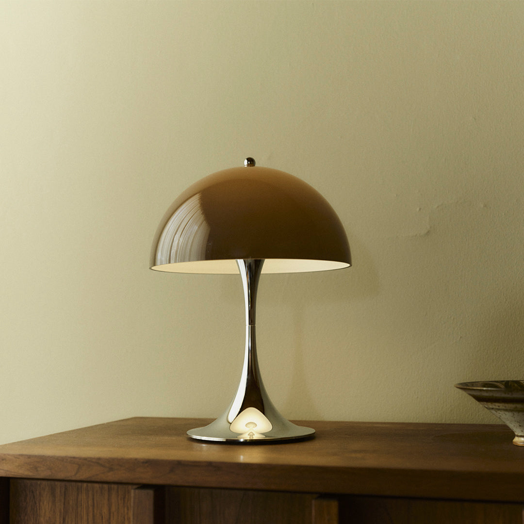 Brown dome lamp with a sleek silver base, perfect for modern decor. Smooth finish adds a touch of elegance.