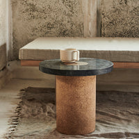 Cork and black marble round side table, minimalist design with neutral tones and natural textures.