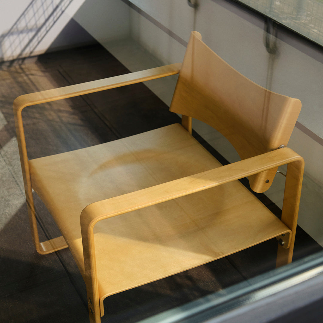 Minimalist light wood chair with a natural finish and smooth, clean lines. Modern design enhances any contemporary space.