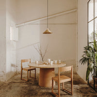 Light wood dining table with matching chairs, featuring a minimalist design against a neutral, textured background.
