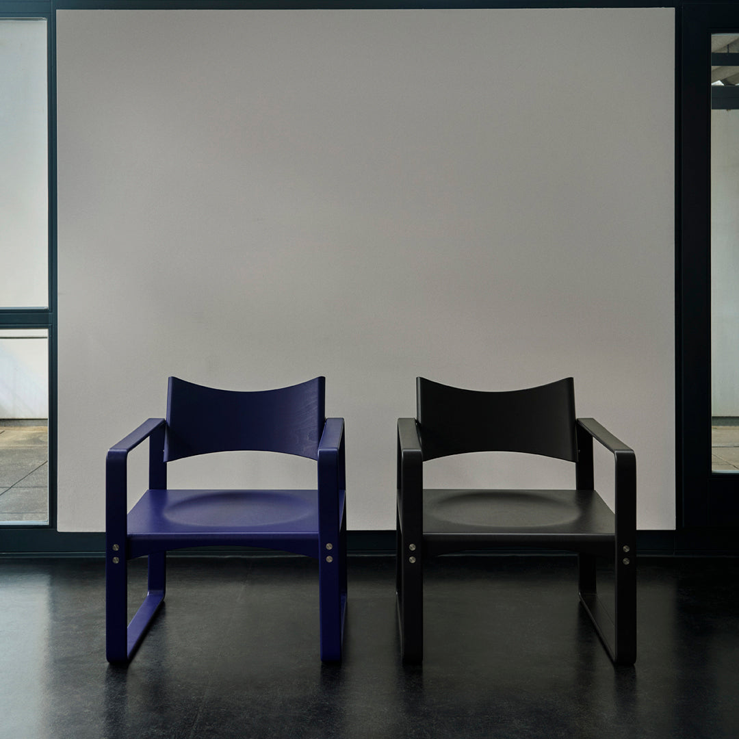 "Modern chairs in deep navy blue and sleek black with minimalistic patterns against a contrasting backdrop."