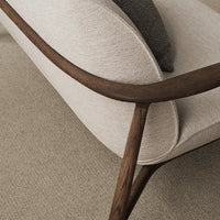 Light beige fabric sofa with a curved wooden frame and grey cushion, showcasing a modern, minimalist design.