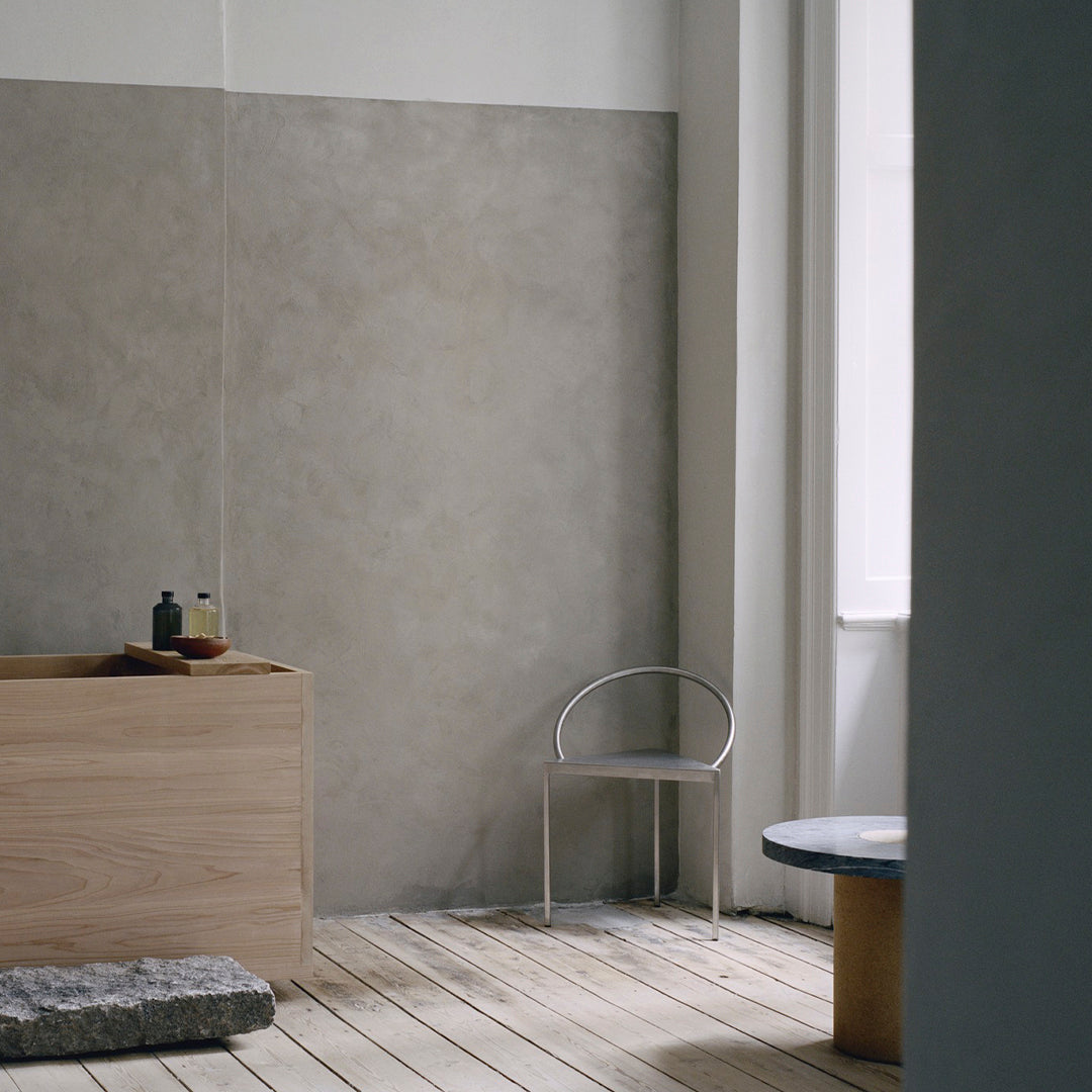 "Minimalist interior showcasing soft gray walls, light wood furniture, and earthy stone accents, enhancing contemporary design."