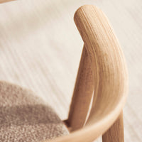 Natural wood grain with smooth curves and a soft beige fabric seat, showcasing a minimalist design.