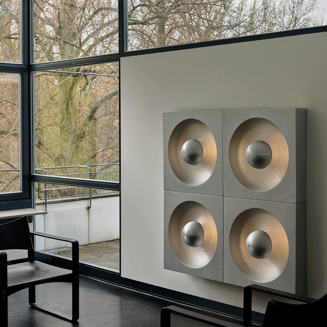 Modern wall art with four circular gold patterns on a sleek gray background, enhancing contemporary decor.