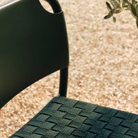 Green woven chair seat with textured pattern, complemented by a sleek black frame. Perfect for modern outdoor settings.