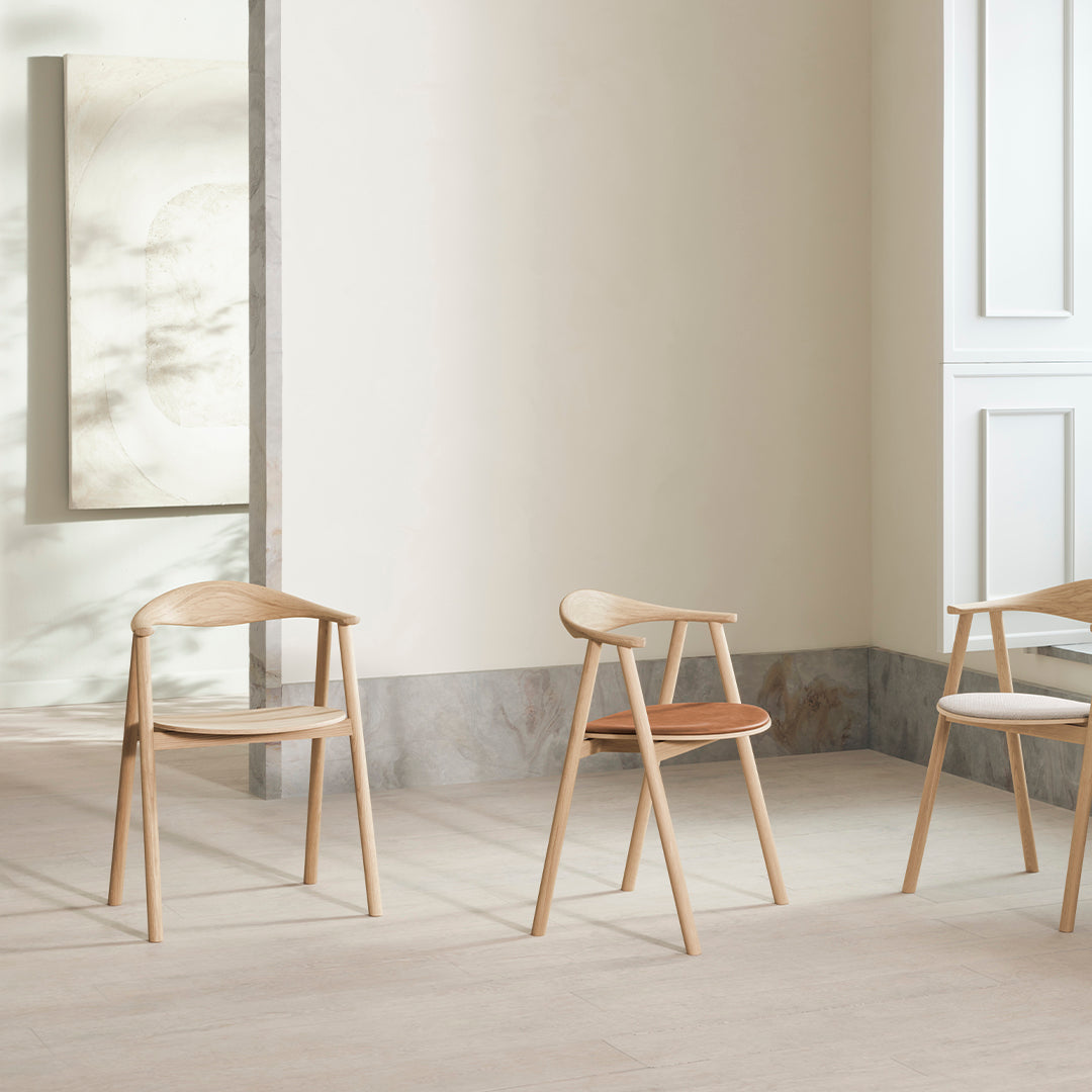 Light wooden chairs with natural finishes and subtle variations in color, featuring smooth lines and minimalistic design.