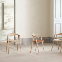 Light wooden chairs with natural finishes and subtle variations in color, featuring smooth lines and minimalistic design.