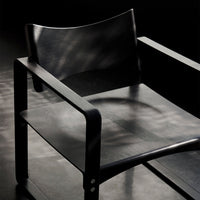 "Minimalist black chair with sleek lines and subtle texture, perfect for modern interiors."