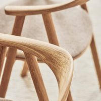 Natural oak wood with soft, neutral fabric in a minimalist, streamlined chair design. Perfect for modern interiors.