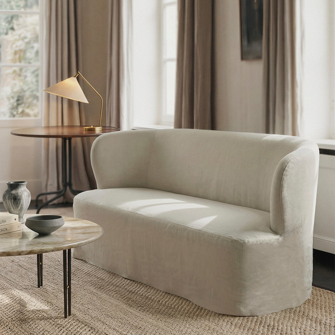 Soft beige sofa with rounded arms, textured fabric, and clean lines, complementing a cozy, neutral room setting.