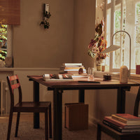 Warm neutral tones with wooden textures, complemented by rich maroon accents and soft natural light.