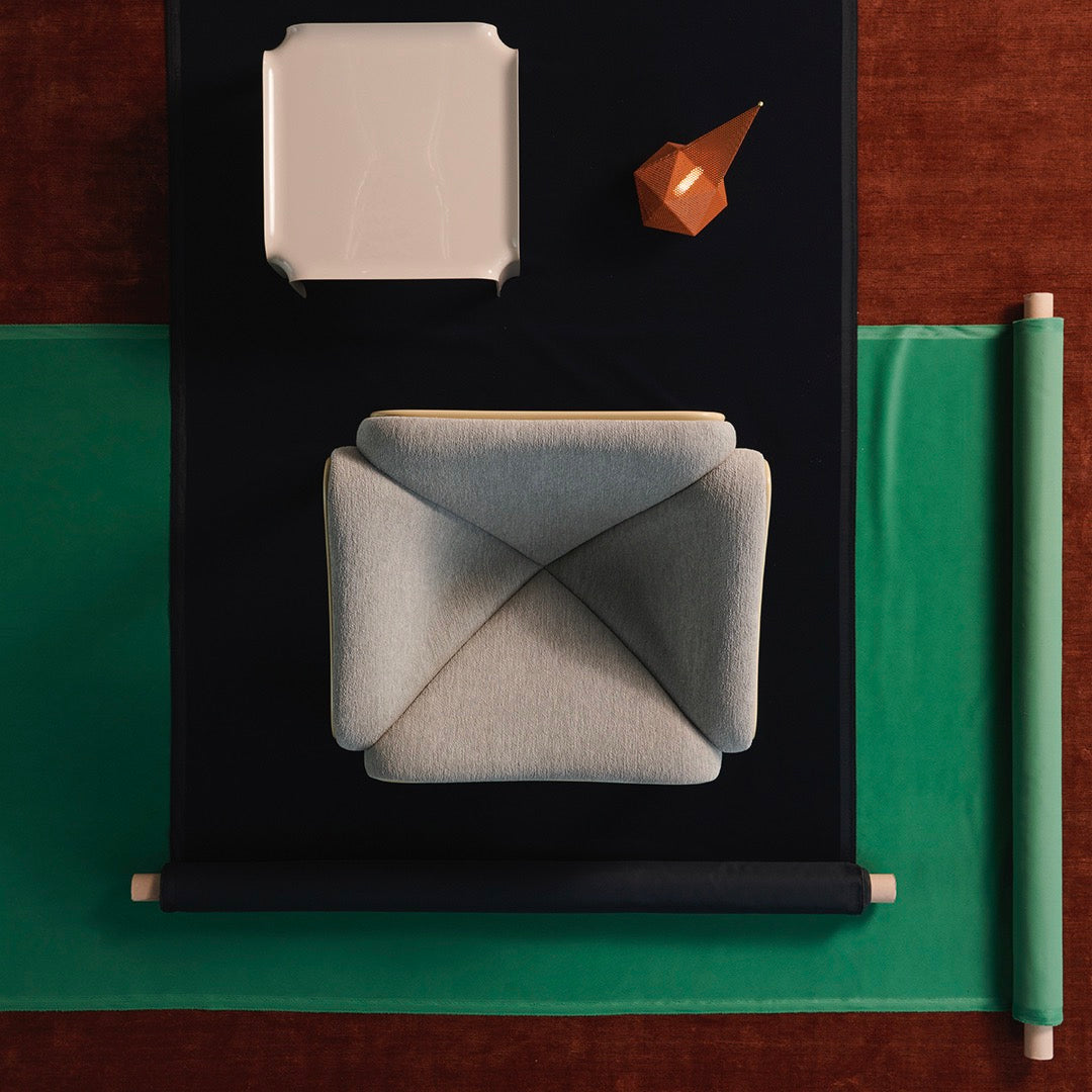 Stylish gray cushion on a dark background, paired with green, clean lines and geometric accents in brown and white.