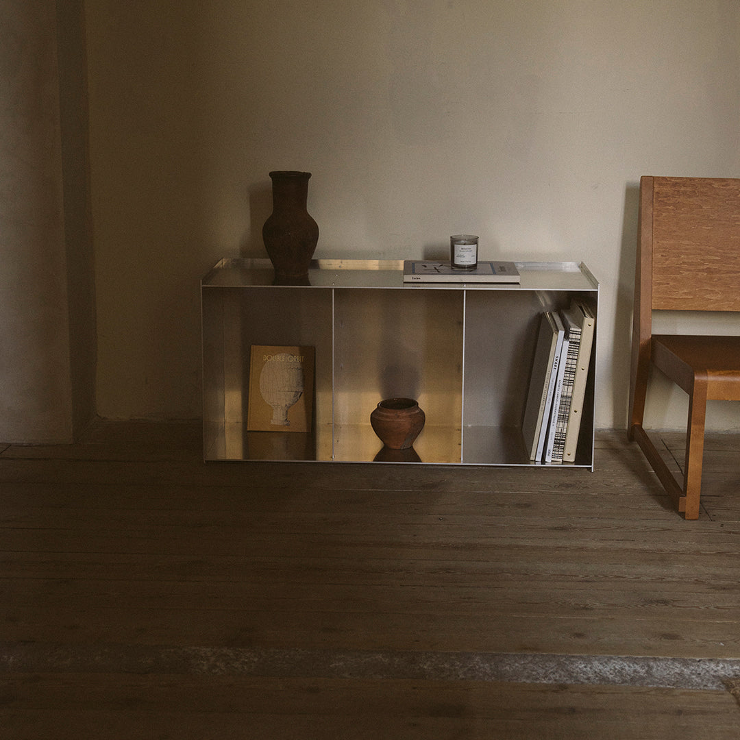 Modern wooden console in neutral tones with metallic accents, framed by warm earth tones and natural textures.