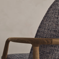 Navy blue and cream textured upholstery with a wooden armrest, showcasing a stylish, modern design.