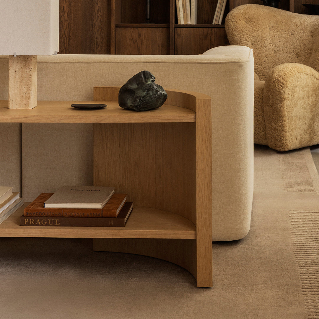 Wooden console table with a natural finish, featuring smooth lines and minimal geometric patterns against a beige backdrop.