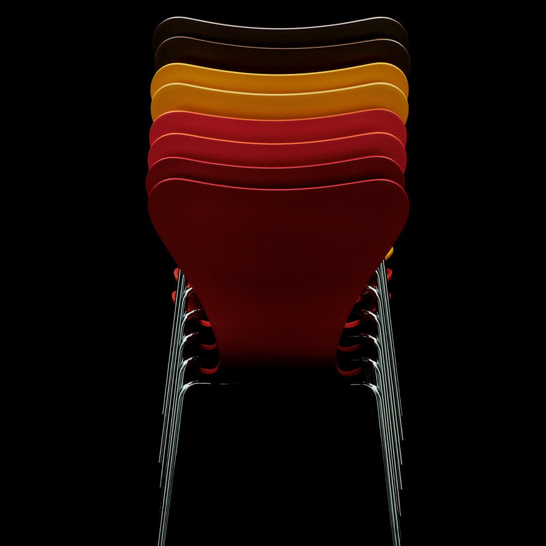 Stacked chairs in vibrant colors: red, yellow, orange, brown, showcasing a sleek design against a dark background.