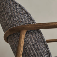 Blue and gray textured upholstery with subtle white flecks, complemented by a warm wooden frame.