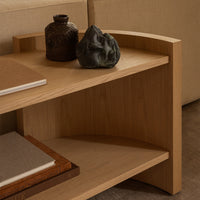 Light wooden shelf with curved edges, featuring natural textures and earthy tones, complemented by dark ceramic accents.