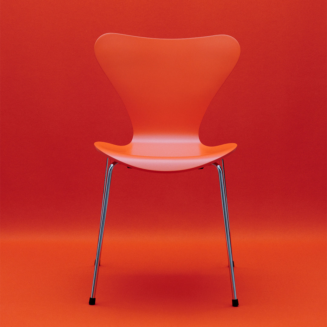 Vibrant orange chair against a solid orange backdrop, featuring a sleek design and chrome legs.