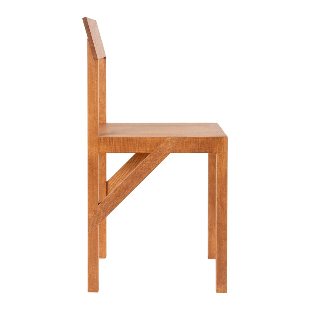 Side view of a minimalist wooden chair in warm amber tones with a smooth, clean finish.