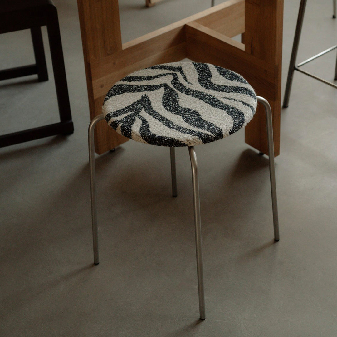 Zebra-patterned stool with black and white colors, featuring a sleek metallic frame.