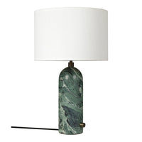 Green marble lamp base with white cylindrical shade and a brass accent, showcasing elegant swirls and textures.