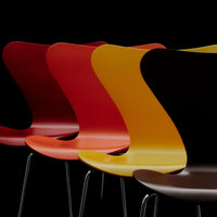 Colorful modern chairs in red, orange, yellow, and brown with sleek, curved designs against a black backdrop.