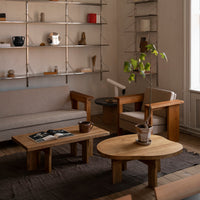 Neutral tones with soft beige, brown wood, and subtle patterns on fabric and rugs, creating a warm, minimalistic interior.