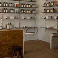Neutral tones with warm amber and dark accents, showcasing minimalist displays and earthy textures in a modern interior.