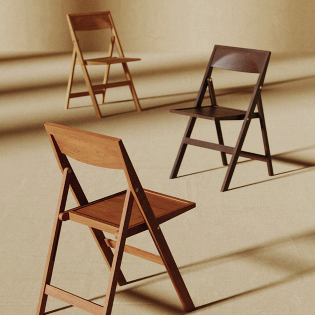 Three wooden folding chairs in light, medium, and dark brown tones on a textured beige background.