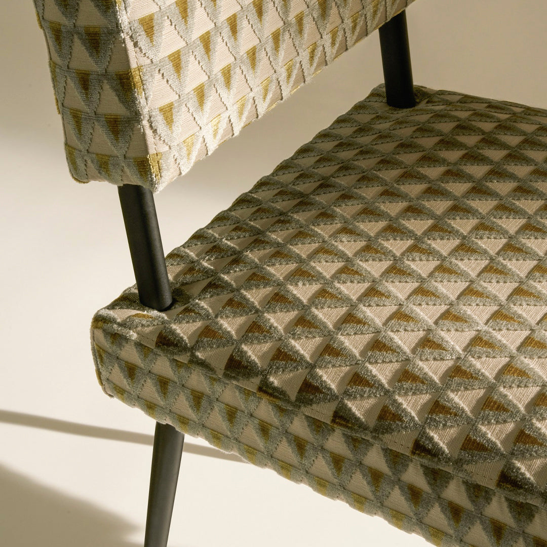 Textured chair featuring a geometric diamond pattern in subtle beige and gray tones with dark metal legs.