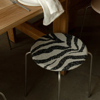 Black and white zebra stripe pattern round stool cushion, modern design with sleek metallic legs.