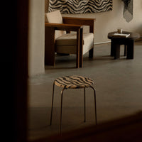 Zebra-patterned stool with a round seat and metal legs, featuring bold black and white colors. Minimalistic design for modern interiors.