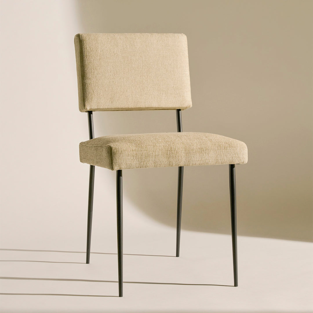 Beige upholstered chair with clean lines and black metal legs, perfect for modern decor.