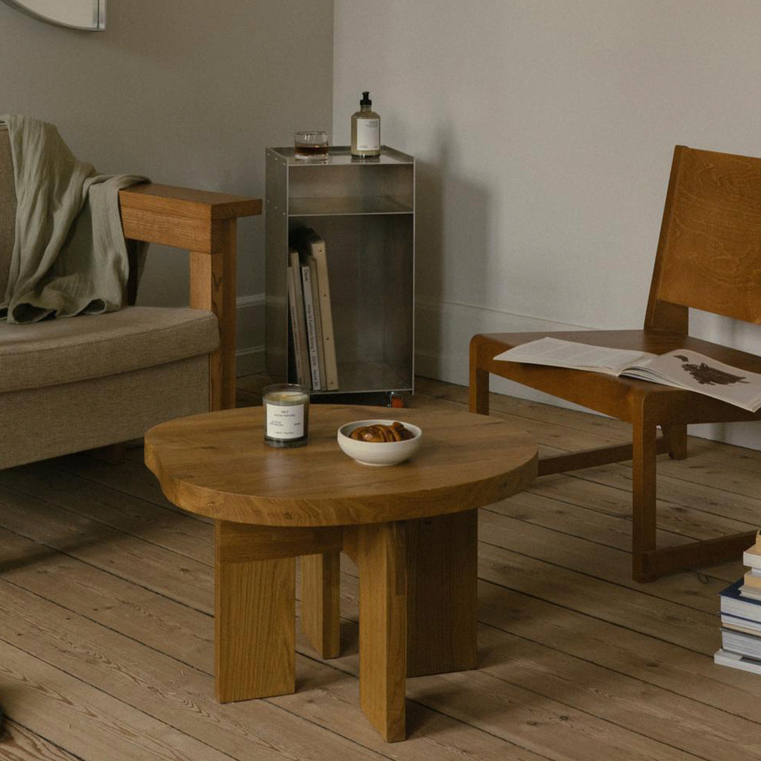 Natural wood coffee table with a warm, honey finish, set in a neutral-toned living room with earthy accents.
