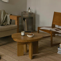 Natural wood coffee table with a warm, honey finish, set in a neutral-toned living room with earthy accents.