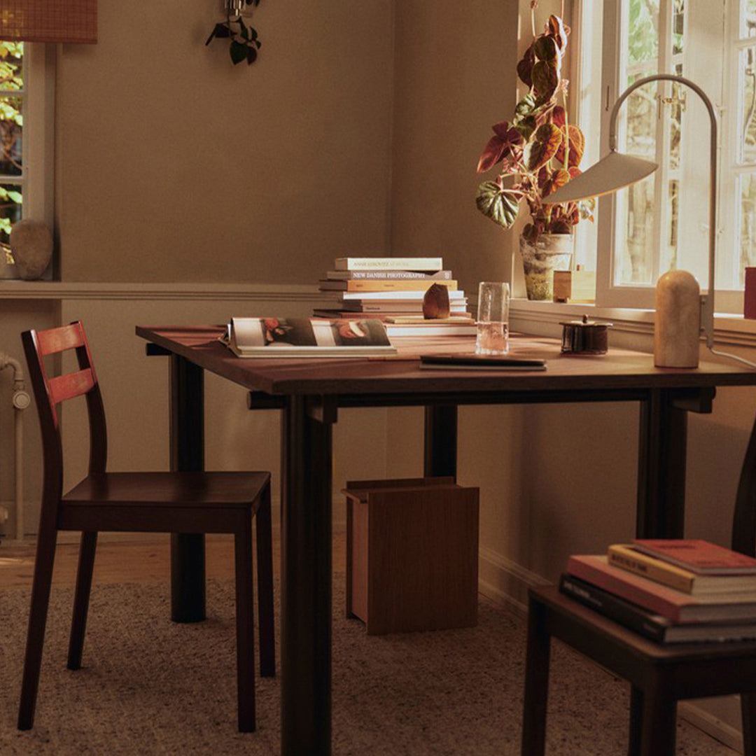 Warm brown wooden table with matching chair, surrounded by neutral tones and soft textures. Perfect for cozy spaces.