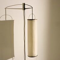 Modern lamp with a minimalist design featuring soft white shades and sleek black accents. Simple patterns enhance elegance.