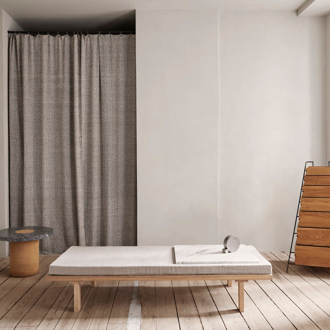 Grey textured curtain, light wooden furniture, neutral-toned space, minimalist design with soft, muted colors.