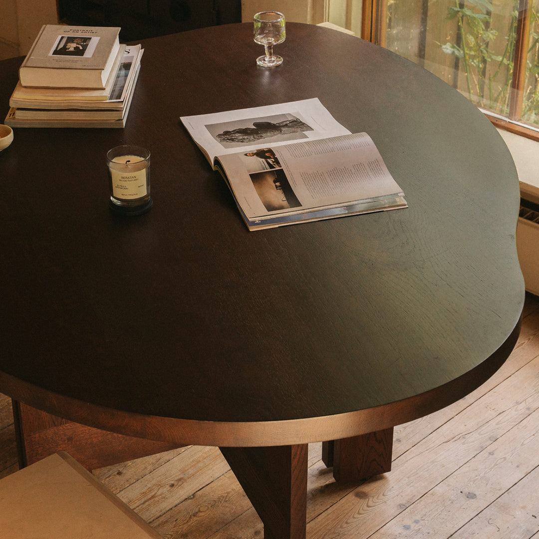 Round wooden table with a dark, smooth surface, featuring subtle patterns and warm lighting illuminating its edges.