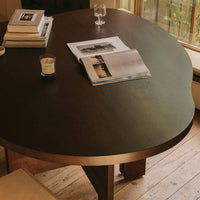 Round wooden table with a dark, smooth surface, featuring subtle patterns and warm lighting illuminating its edges.