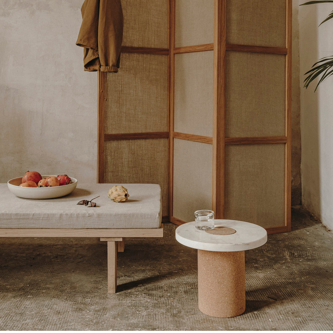 "Neutral tones with a textured, cork base and white circular top. Earthy colors complement minimalist decor."