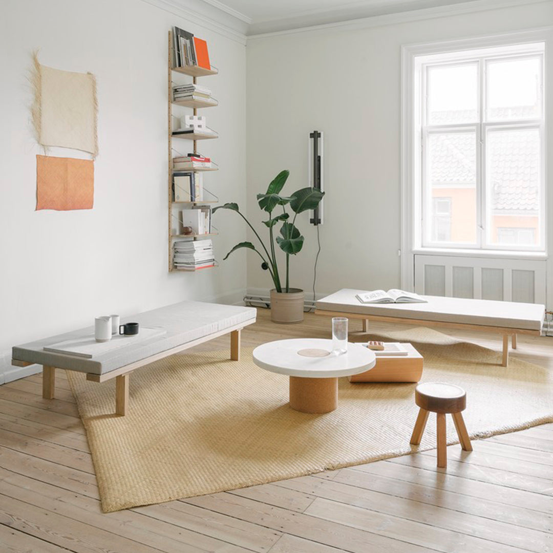 Modern living room featuring neutral tones, beige accents, and minimalist wooden furniture with geometric patterns.